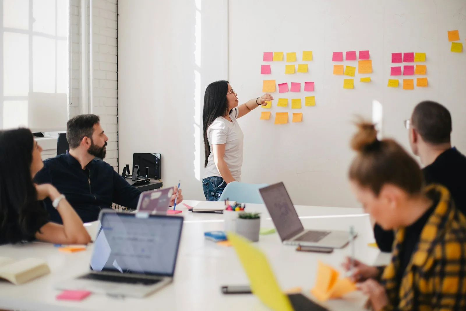 An agency team planning client work on a wall of sticky notes